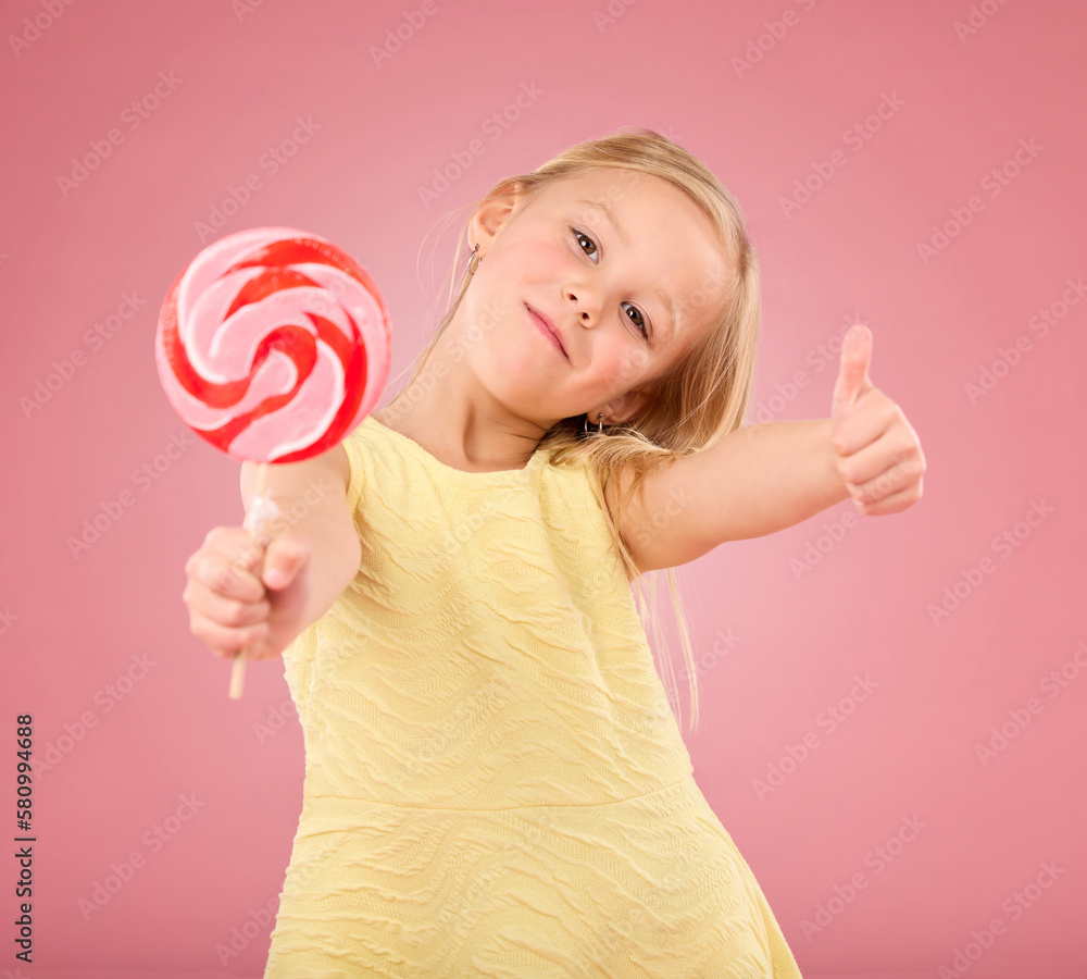 Candy, thumbs up and lollipop with portrait of girl in studio for sugar, party and carnival food isolated on pink background. Cute, positive and youth with child or eating snack for playful and treat