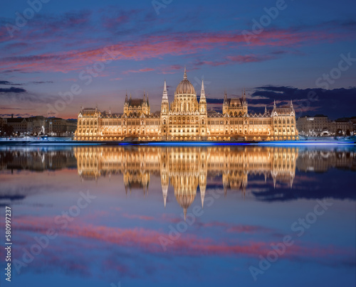 view on Parliament building in Budapest with fantastic perfect sky and reflection in water at dusk. calm Danube river. Popular Travel destinations. creative image used as background.