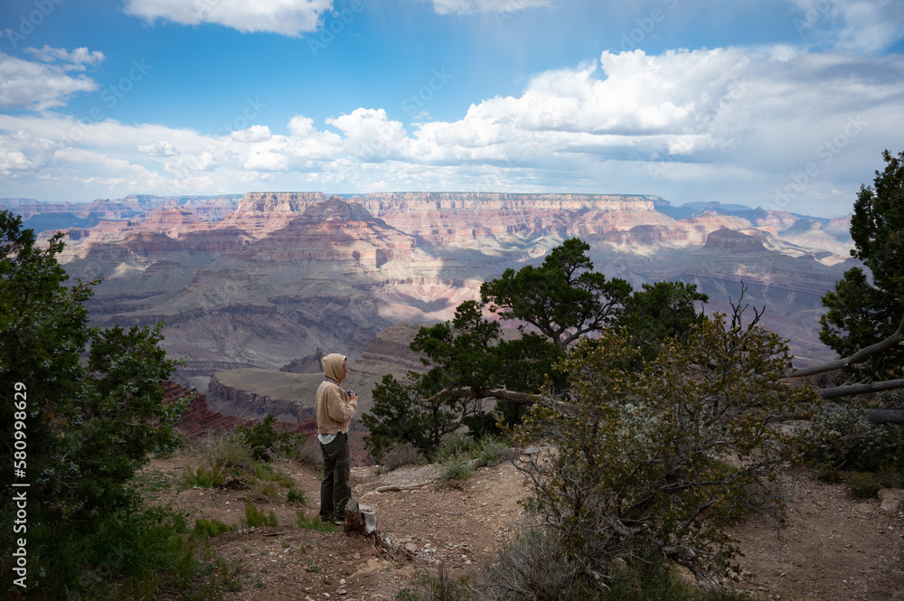 Young girl with sweatshirt and hoodie taking pictures in the nature of the Grand Canyon Young girl with sweatshirt and hoodie taking pictures in the nature of the Grand Canyon