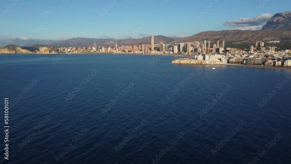Aerial view of Benidorm and the mountains range inland. Panning right while ascending. Aerial view of Benidorm and the mountains range inland. Panning right while ascending.