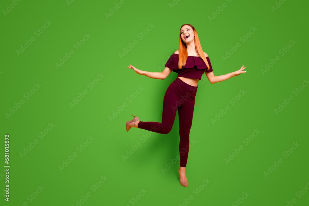 Full-size portrait of beautiful girl in beige shoes that stands one leg spreads joyfully hands isolated on yellow background with copy space for text Full-size portrait of beautiful girl in beige shoes that stands one leg spreads joyfully hands isolated on yellow background with copy space for text