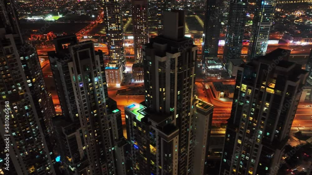 Cinematic aerial view of Downtown Dubai skyscrapers lit with night light revealing iconic Sheikh Zayed Road intersection, UAE Cinematic aerial view of Downtown Dubai skyscrapers lit with night light revealing iconic Sheikh Zayed Road intersection, UAE