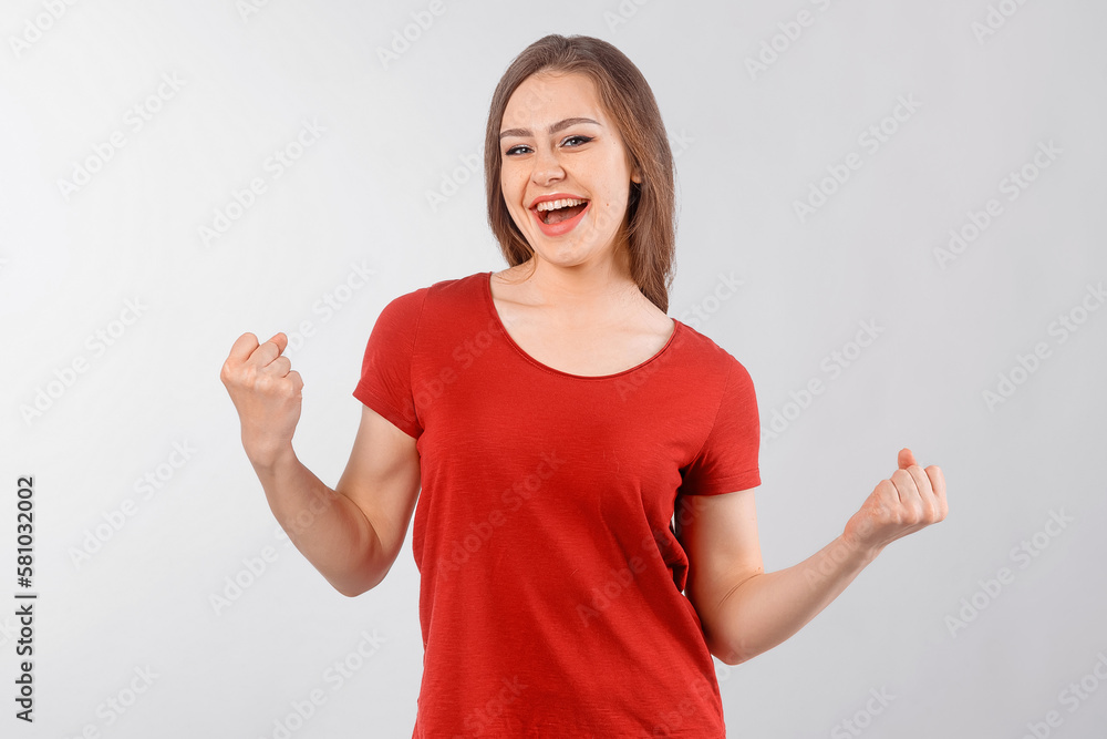 Portrait of joyful excited and emotive happy female student cheering for favorite team yelling from excitement and joy clenching fists in victory or triumph gesture. Emotions concept Portrait of joyful excited and emotive happy female student cheering for favorite team yelling from excitement and joy clenching fists in victory or triumph gesture. Emotions concept