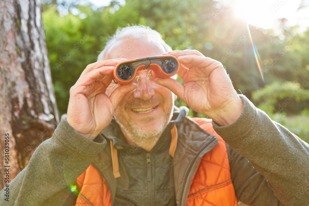 Elderly man looking through binoculars on sunny day Elderly man looking through binoculars on sunny day