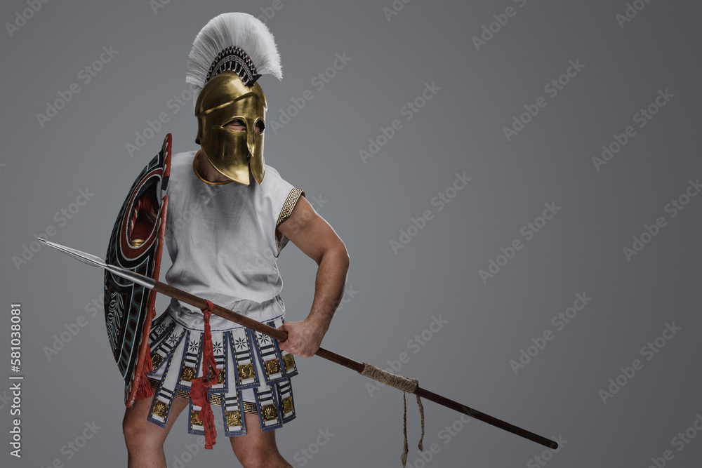 Studio shot of attacking greek spearman with shield dressed in tunic and plumed helmet. Studio shot of attacking greek spearman with shield dressed in tunic and plumed helmet.