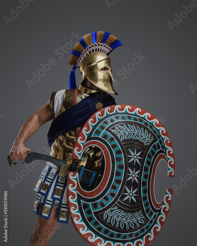 Portrait of isolated on gray background general from ancient greece with sword.