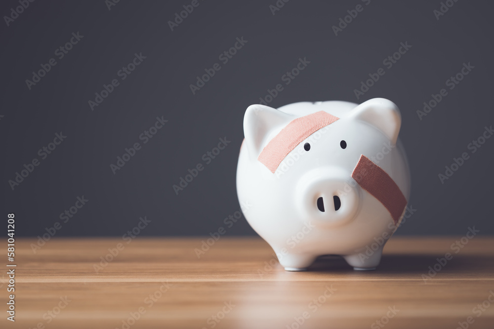 Financial problem, Bankrupt or fail in business concept. White piggy bank with plastic adhesive bandages on wooden desk with dark copy space wall background. Fail, Bankrupt or unsuccessful idea. - obrazy, fototapety, plakaty 