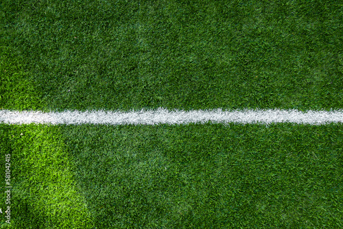 White stripe markings on the green grass of the soccer field, copy space background.
