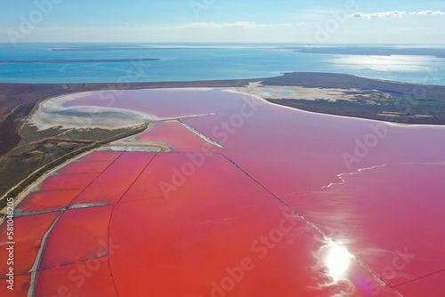 Aerial view of the colorful pink salt lake and the Black sea in Kherson region, Ukraine. Salt production for the food industry, cosmetology, and spa.