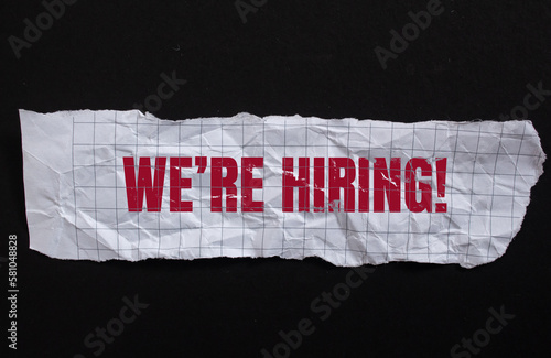 we're hiring! written on torn paper. Business concept photo.