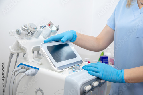 Fotografie Cropped professional dermatologist setting up and using hydra facial peel machine with hand pieces cables
