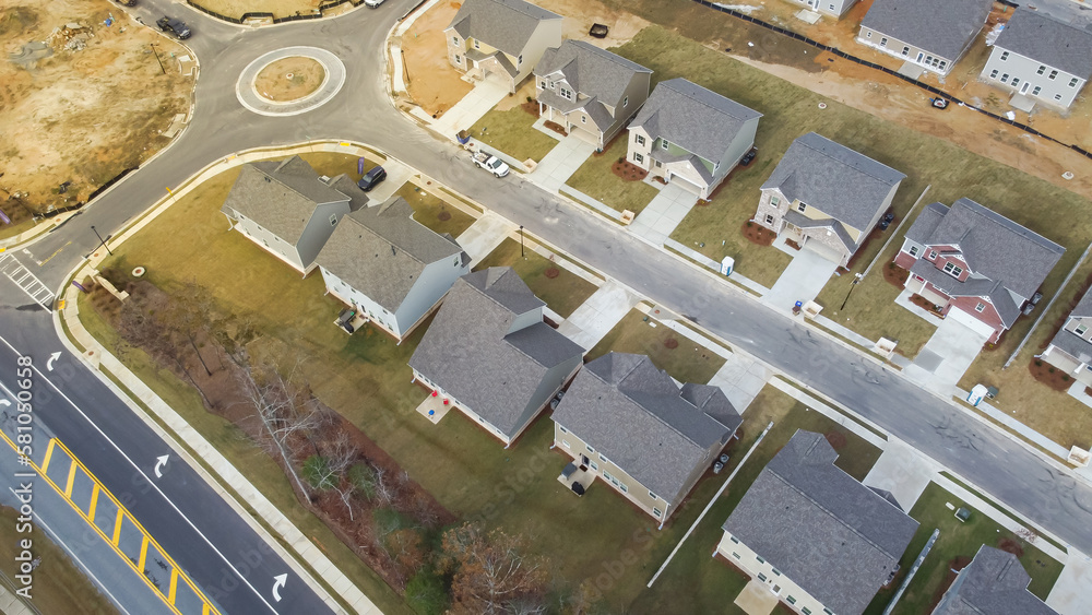 Medium density neighborhood with new development dwelling units houses near roundabout traffic circle residential area in Flowery Branch, Georgia, USA Medium density neighborhood with new development dwelling units houses near roundabout traffic circle residential area in Flowery Branch, Georgia, USA