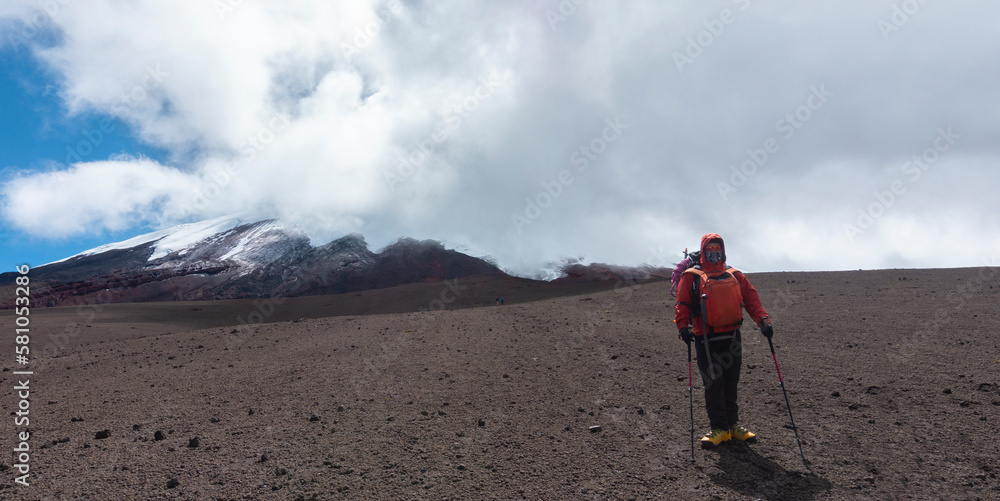 Young male climber walking alone on the sandbank of Cotopaxi volcano on a cloudy day Young male climber walking alone on the sandbank of Cotopaxi volcano on a cloudy day