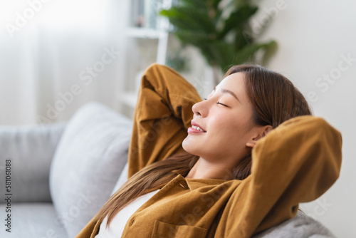 Fotografie Young woman enjoying mind free moment relax and calm on the sofa at home
