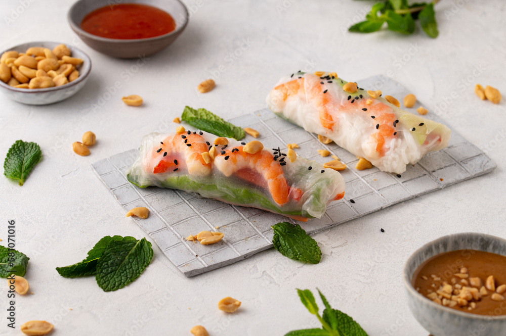 Summer rolls with fresh vegetables and shrimps and peanut sauce. Vietnamese appetizer. Salad spring rolls with prawns. Healthy food concept Summer rolls with fresh vegetables and shrimps and peanut sauce. Vietnamese appetizer. Salad spring rolls with prawns. Healthy food concept