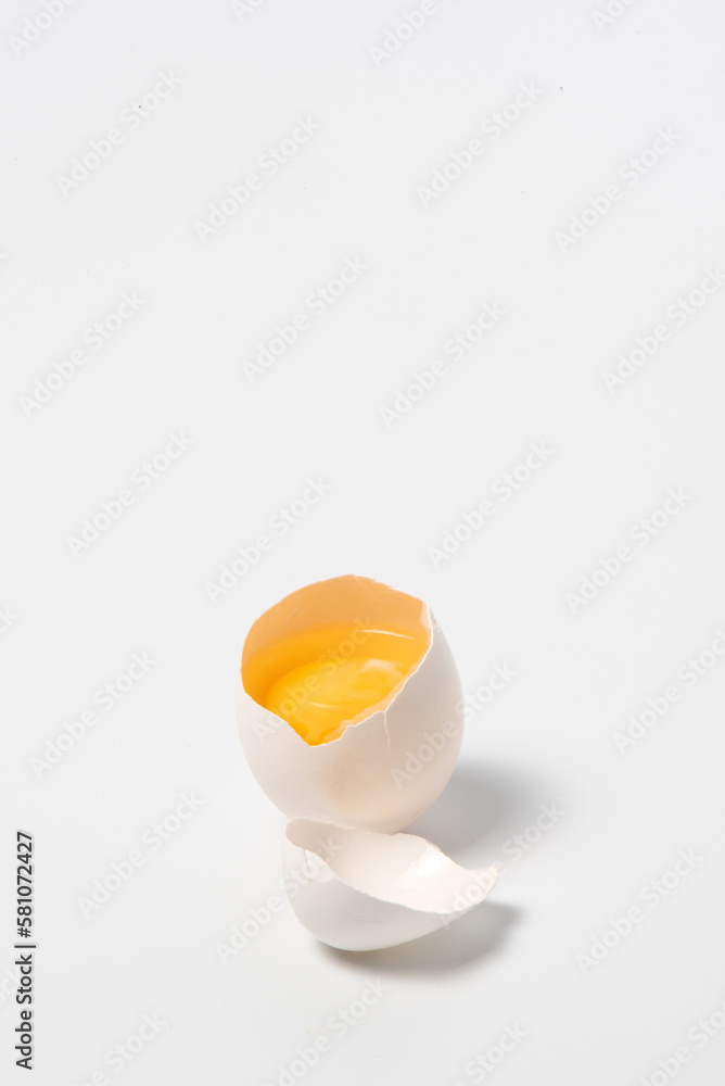 Chicken egg with cut top on a white background with shadow. Cracked white chicken egg with visible yolk Isolated on white. Vertical photo with copy space. High quality photo Chicken egg with cut top on a white background with shadow. Cracked white chicken egg with visible yolk Isolated on white. Vertical photo with copy space. High quality photo