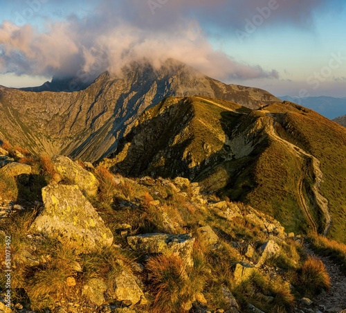 Sunrise from the ridge of the Western Tatras, Rohace with a view of the Salatin mountain with grass illuminated by the rising sun, camping and bivouac in nature. Tatras, tourist theme, tourist trail.
