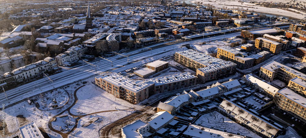 Aerial view of residential complex after a snow storm with Ettegerpark seen from above with rooftops full of solar panels covered in white in urban development of real estate investment project.