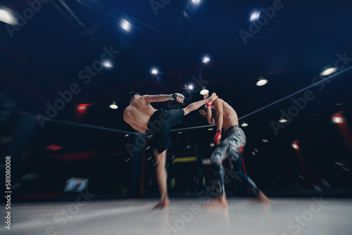 MMA Boxers fighters in fights without rules in ring cargo octagon hit kick, dark background spot light