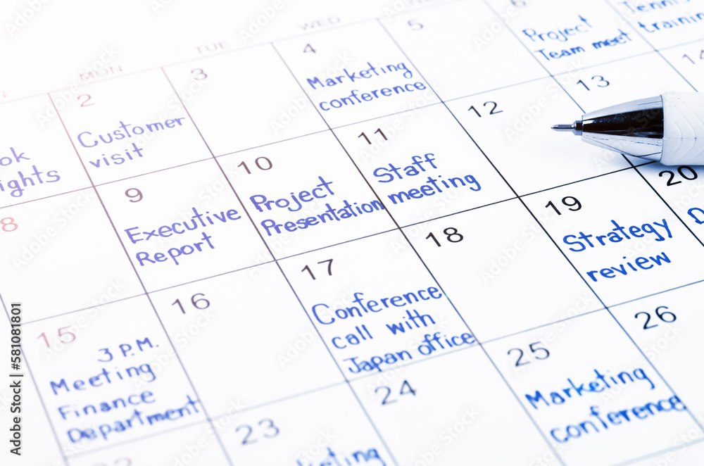 The handwriting scheduling appointments on calendar sheet with pen. The handwriting scheduling appointments on calendar sheet with pen.