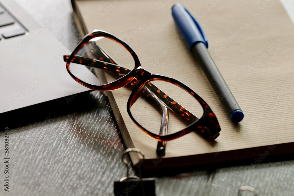 Okulary i notes z pisakiem na biurku. Niezbędne do pracy i biznesu.  Finansowe spotkanie - obrazy, fototapety, plakaty 