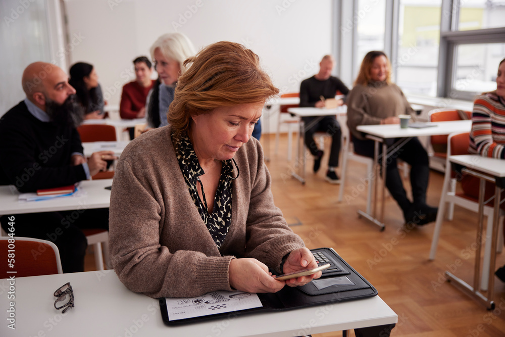 Business woman using cell phone during workshop Business woman using cell phone during workshop