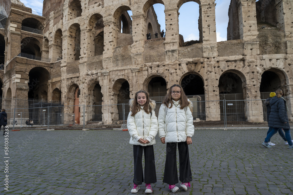 Ritratto di sorelle gemelle di 8 anni con sullo sfondo il Colosseo a Roma.