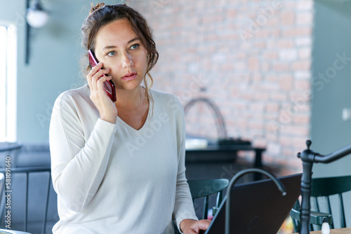 Foto Young woman caller talking on the phone at home