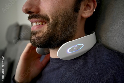 Man enjoying the benefits of an electric neck massager. The device helps to relieve tension and promote relaxation, making it an ideal tool for anyone seeking a little self-care. 