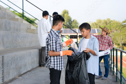 Obraz na plátne group of private sector volunteer teens and teacher help collect garbage in the
