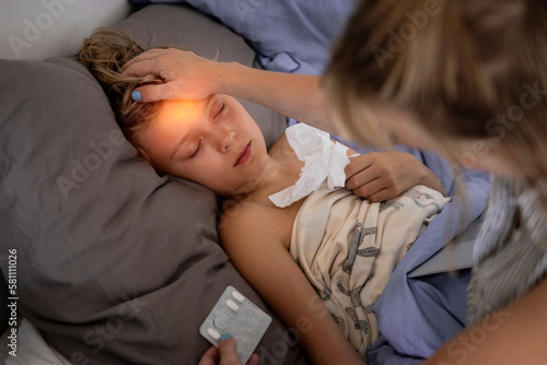 Mother applying medicine to sick boy photo