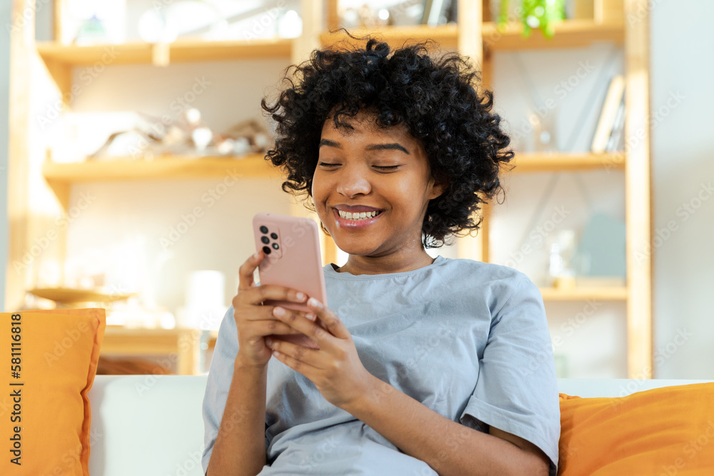 African girl holding smartphone touch screen typing scroll page at home. Woman with cell phone surfing internet using social media apps playing game. Shopping online Internet news cellphone addiction. African girl holding smartphone touch screen typing scroll page at home. Woman with cell phone surfing internet using social media apps playing game. Shopping online Internet news cellphone addiction.