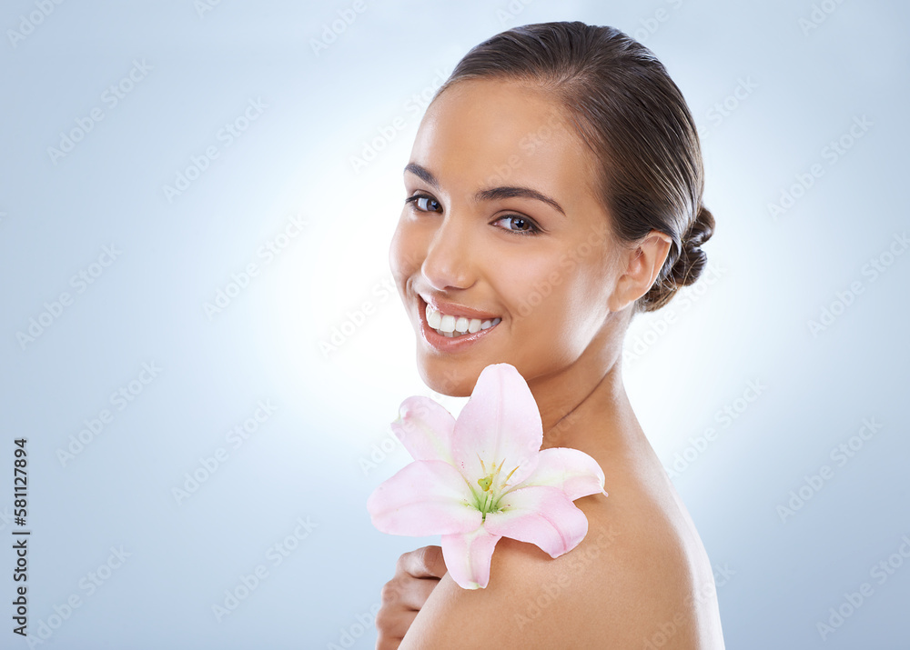 As delicate as can be...Studio shot of a beautiful young woman holding a flower. As delicate as can be...Studio shot of a beautiful young woman holding a flower.