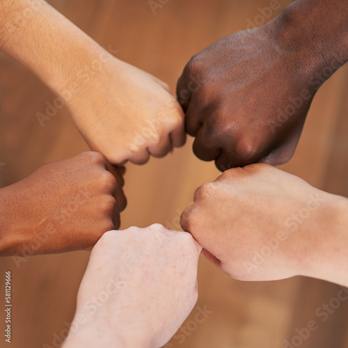 Circle of diverse hands, fists in circle, different skin colours unity teamwork photo