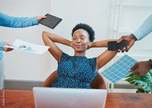 Young Black woman relaxes in her office while coworkers make demands