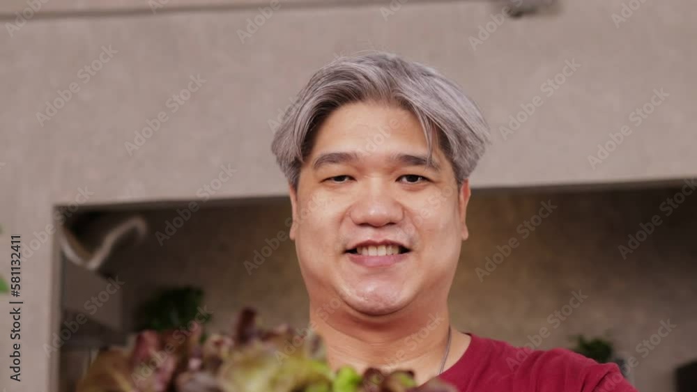 Asian fat man smiling happily holding a wooden basket of organic vegetables. Healthy food concept, weight loss