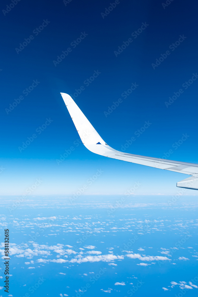 View of the blue sky and fluffy clouds from the window of the plane. View of the blue sky and fluffy clouds from the window of the plane.