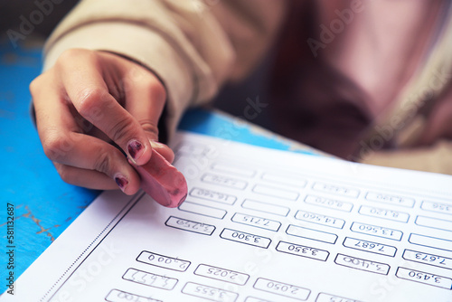 Kid using eraser or rubber for erase pencil wrtie on paper in learning activity photo