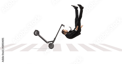 Businessman tumbling with an electric scooter on a pedestrian crossing