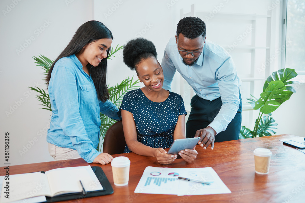Fototapeta premium Black business woman sits and shows standing colleagues report on digital tablet