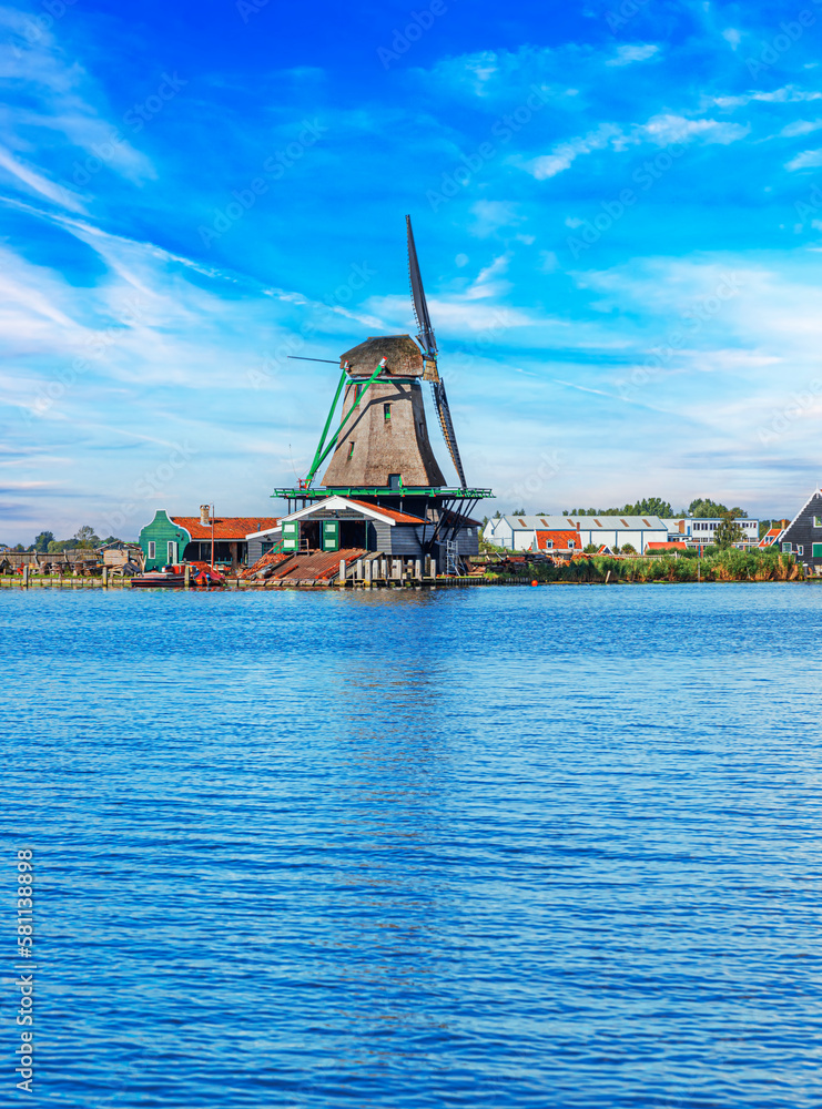 Traditional dutch windmill near the canal. Windmill in Zaanse Schans village Netherlands, Holland.