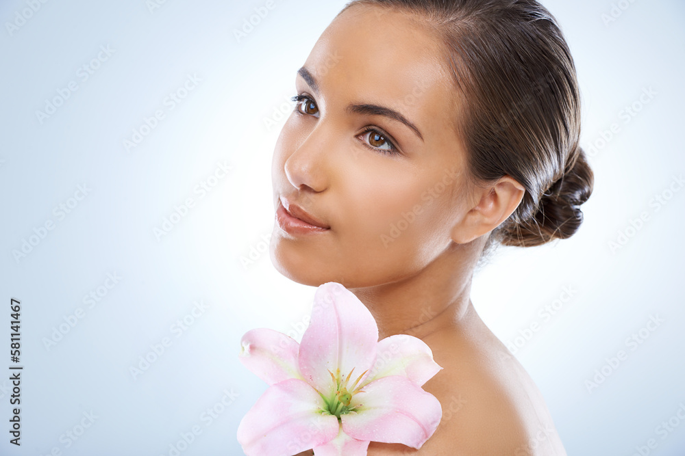 Nature meets natural beauty. Studio shot of a beautiful young woman holding a flower. Nature meets natural beauty. Studio shot of a beautiful young woman holding a flower.
