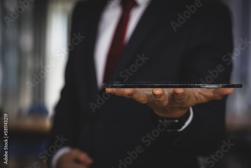 Close up of a businessman holding a tablet.