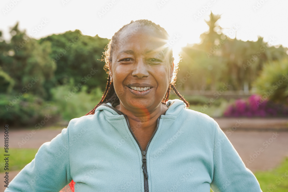 Happy african senior woman smiling on camera after sport workout at city park - Joyful elderly and healthy lifestyle concept Happy african senior woman smiling on camera after sport workout at city park - Joyful elderly and healthy lifestyle concept
