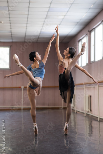 Two Asian ballerinas are dancing in the class. 