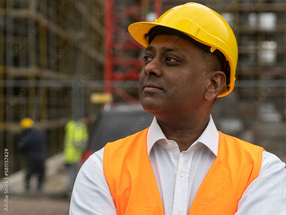 Profile portrait of an absorbed civil engineer or factory worker wearing a safety helmet and looking aside Profile portrait of an absorbed civil engineer or factory worker wearing a safety helmet and looking aside