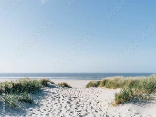 Beautiful shot of white sandy beach with seascape under blue sky
