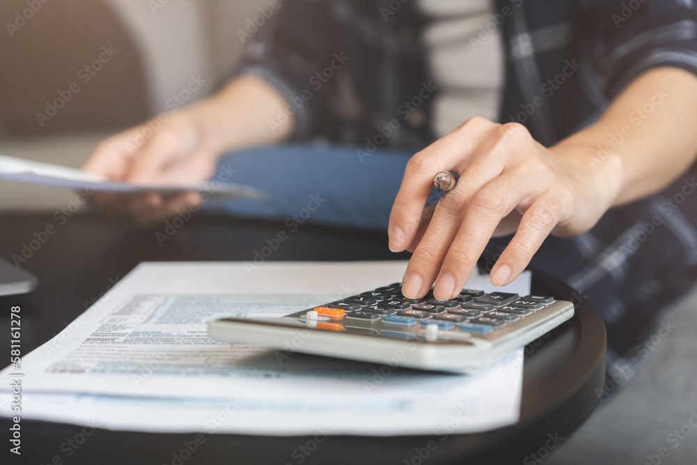 Deduction planning concept. Asian young woman hand using calculator to calculating balance prepare tax reduction income, cost budget expenses for pay money form personal Individual Income Tax Return. - obrazy, fototapety, plakaty 