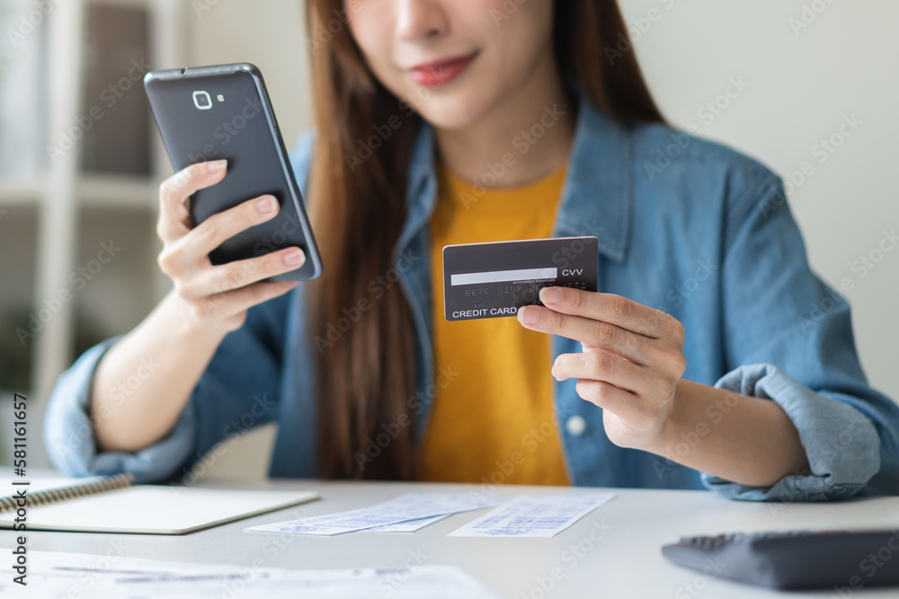 Φωτογραφία Online internet banking, smile asian young woman hand holding credit card to payment spending, using mobile phone scan qr code to transfer or pay money without cash at home