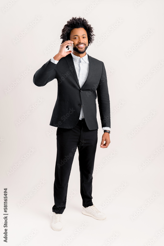 Happy friendly male small business owner talking on the smartphone standing isolated on white, full length. Smiling successful contemporary man manager in formal wear holding phone call, copy space Happy friendly male small business owner talking on the smartphone standing isolated on white, full length. Smiling successful contemporary man manager in formal wear holding phone call, copy space